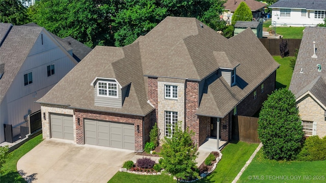 3528 S Wheeling Ave, Tulsa, OK 74105 - view of front facade with brick siding, driveway, roof with shingles, and an attached garage