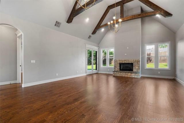 3528 S Wheeling Ave, Tulsa, OK 74105 - unfurnished living room featuring high vaulted ceiling, beamed ceiling, a stone fireplace, wood finished floors, and arched walkways