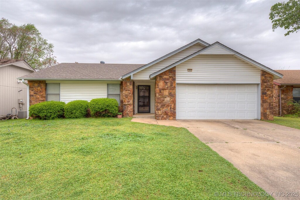 single story home with stone siding, driveway, and a front lawn