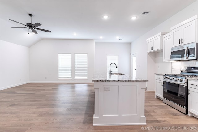 kitchen featuring a ceiling fan, light stone countertops, white cabinetry, a sink, and stainless steel appliances