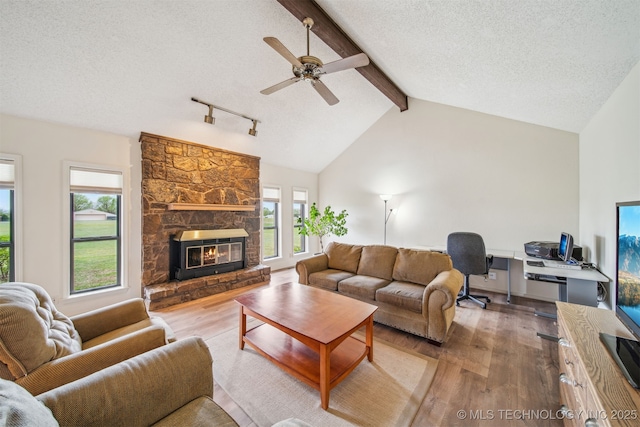 13542 N 155th E Ave, Collinsville, OK 74021 - living area featuring wood finished floors, plenty of natural light, ceiling fan, a textured ceiling, and a stone fireplace