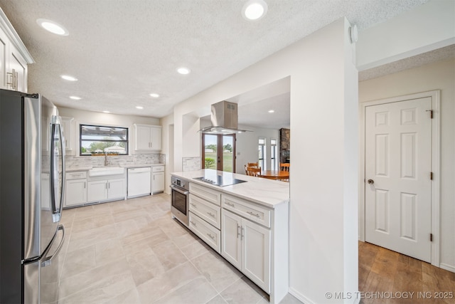 13542 N 155th E Ave, Collinsville, OK 74021 - kitchen with appliances with stainless steel finishes, island exhaust hood, white cabinets, decorative backsplash, and light stone counters