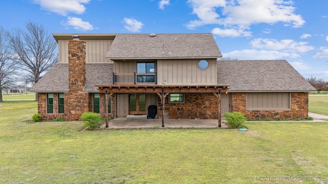 13542 N 155th E Ave, Collinsville, OK 74021 - back of property with stone siding, a patio, a yard, board and batten siding, and roof with shingles