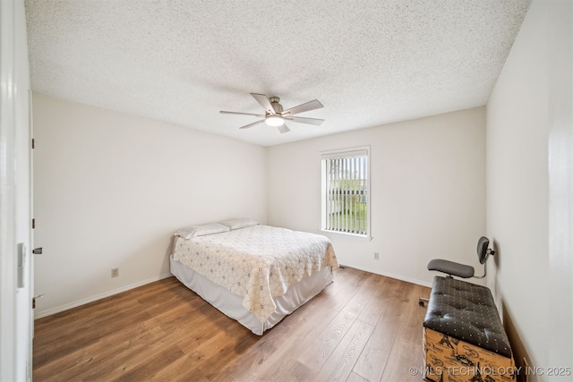 13542 N 155th E Ave, Collinsville, OK 74021 - bedroom with wood finished floors, ceiling fan, and a textured ceiling