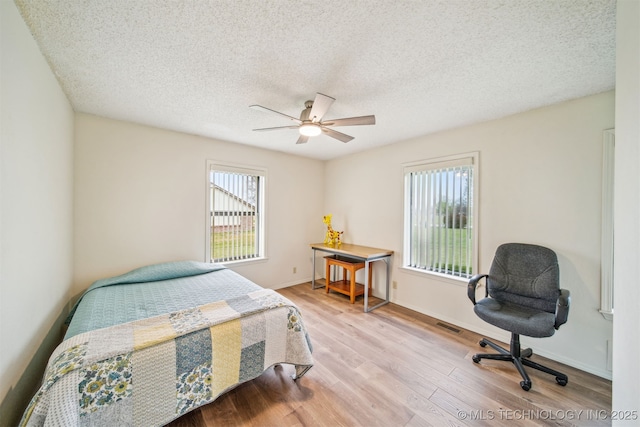 13542 N 155th E Ave, Collinsville, OK 74021 - bedroom featuring wood finished floors, a textured ceiling, and ceiling fan