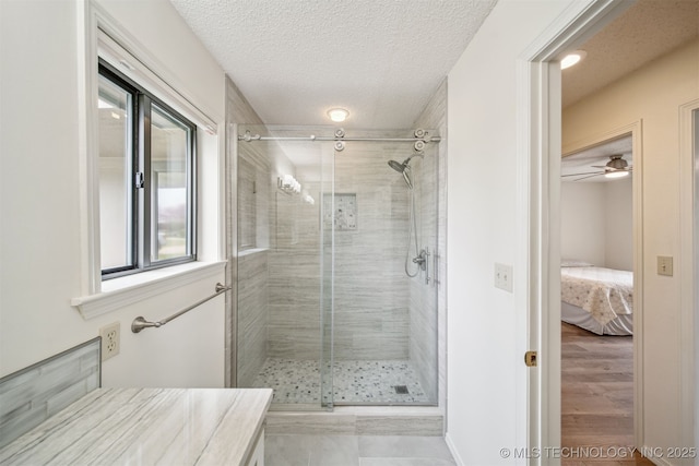 13542 N 155th E Ave, Collinsville, OK 74021 - bathroom featuring a stall shower, ensuite bathroom, a textured ceiling, vanity, and a ceiling fan
