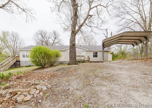 exterior space featuring a deck, driveway, and a detached carport