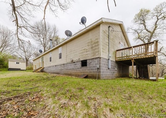 back of house featuring a wooden deck and a lawn