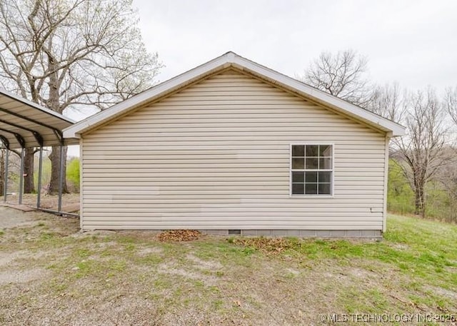 view of side of home with a detached carport and crawl space
