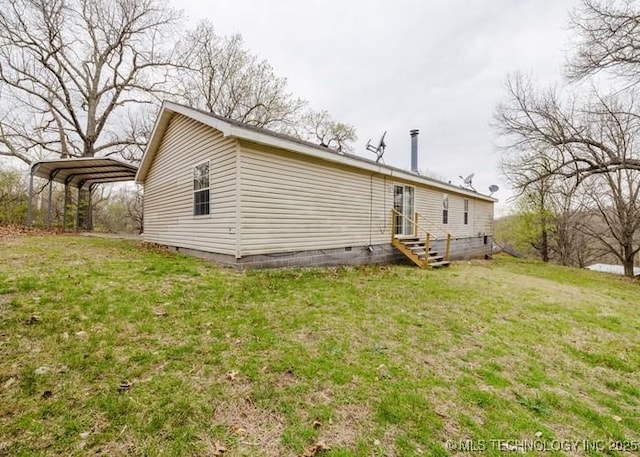 back of house with a detached carport, entry steps, crawl space, and a lawn
