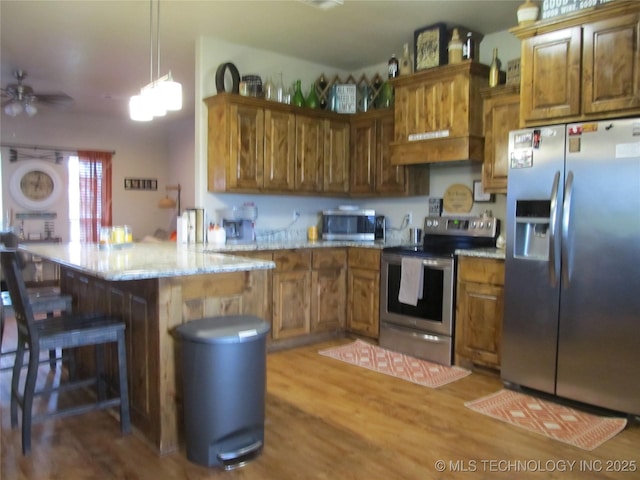 60 S Kaylee Rd, Calera, OK 74730 - kitchen featuring brown cabinetry, a peninsula, and appliances with stainless steel finishes