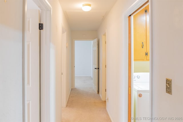 hall featuring washer / dryer and light carpet