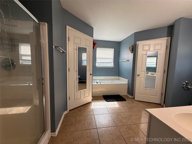 full bathroom with tile patterned flooring, a wealth of natural light, a garden tub, and a shower stall