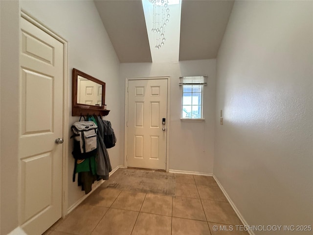 entryway with baseboards and light tile patterned floors