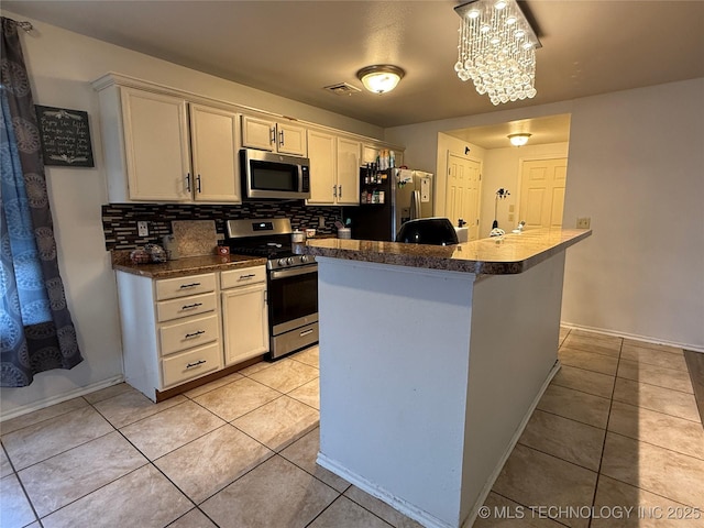 kitchen featuring visible vents, backsplash, light tile patterned floors, and stainless steel appliances