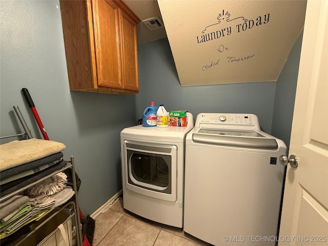 clothes washing area featuring light tile patterned floors, baseboards, visible vents, cabinet space, and washer and dryer