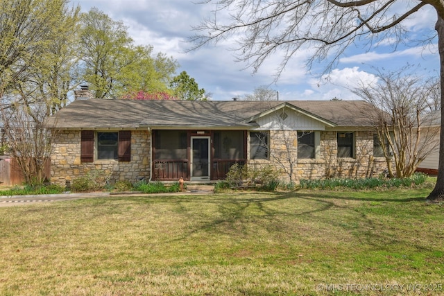 single story home featuring stone siding, a chimney, a sunroom, and a front lawn