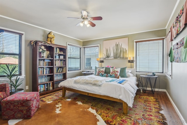 bedroom with a ceiling fan, ornamental molding, baseboards, and wood finished floors