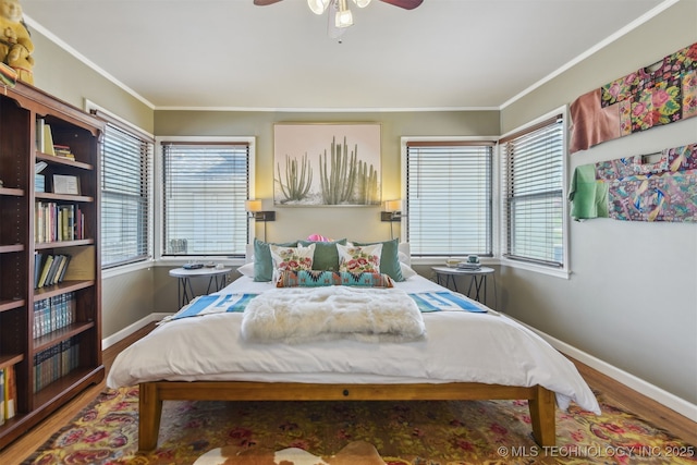 bedroom with a ceiling fan, ornamental molding, baseboards, and wood finished floors