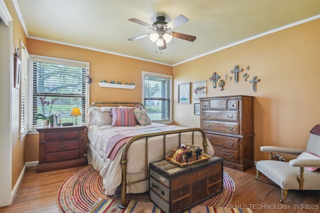 bedroom with a ceiling fan, crown molding, baseboards, and light wood-type flooring