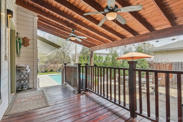 wooden terrace with fence, a ceiling fan, and an outdoor pool