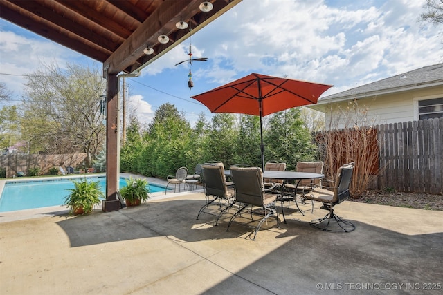 view of patio / terrace featuring outdoor dining space, fence, and a fenced in pool