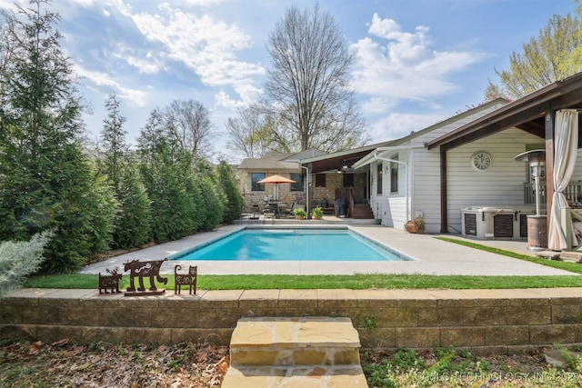 outdoor pool featuring central AC unit and a patio