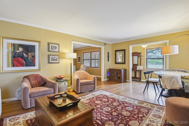 living room featuring baseboards, wood finished floors, and ornamental molding