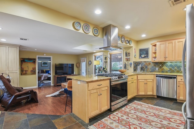 kitchen with open floor plan, island range hood, visible vents, a peninsula, and appliances with stainless steel finishes