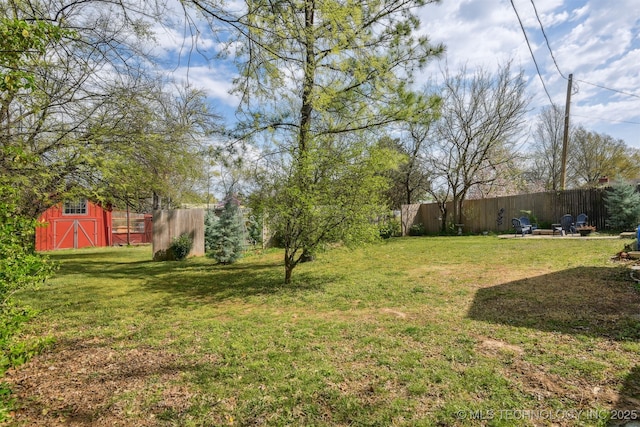 view of yard with an outdoor structure, a storage unit, and fence