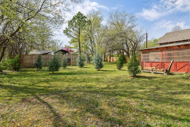 view of yard with an outbuilding and fence