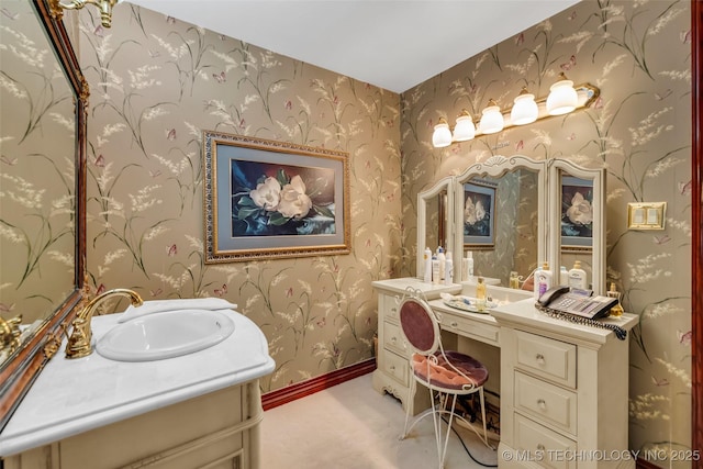 bathroom featuring wallpapered walls, vanity, and baseboards