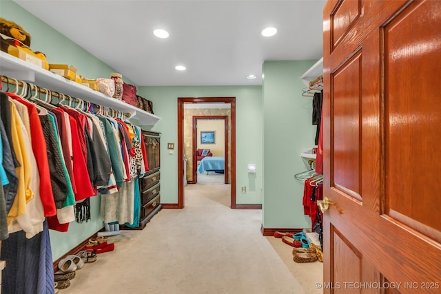 spacious closet featuring light colored carpet