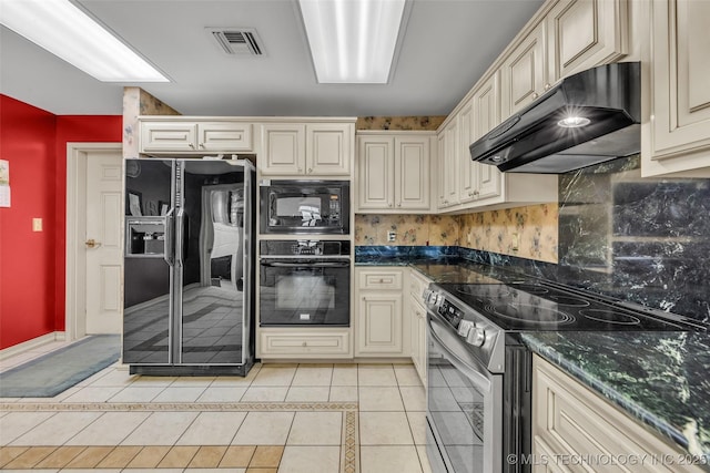 kitchen featuring light tile patterned floors, under cabinet range hood, cream cabinets, visible vents, and black appliances