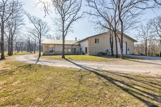 view of front of home featuring dirt driveway, a front lawn, and central AC