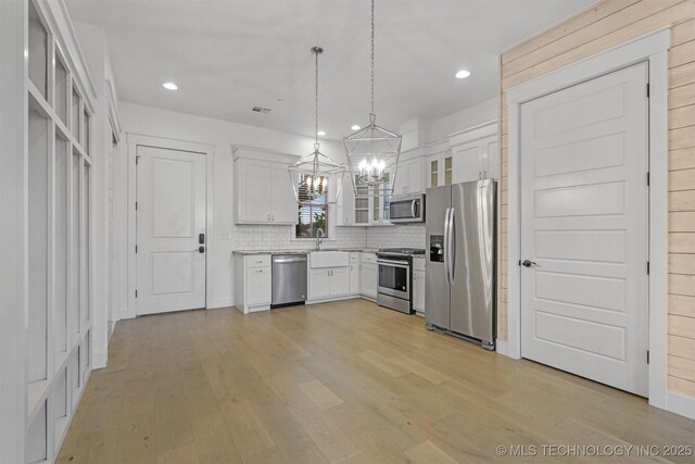 29 Water St Unit 4, Carlton Landing, OK 74432 - kitchen featuring white cabinetry, glass insert cabinets, light wood-type flooring, stainless steel appliances, and an inviting chandelier