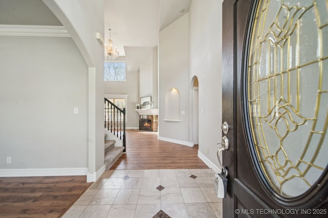 12916 E 181st St S, Bixby, OK 74008 - entrance foyer featuring arched walkways, stairs, baseboards, light tile patterned floors, and a towering ceiling