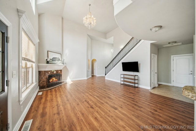 12916 E 181st St S, Bixby, OK 74008 - unfurnished living room with a premium fireplace, wood finished floors, stairway, arched walkways, and a chandelier