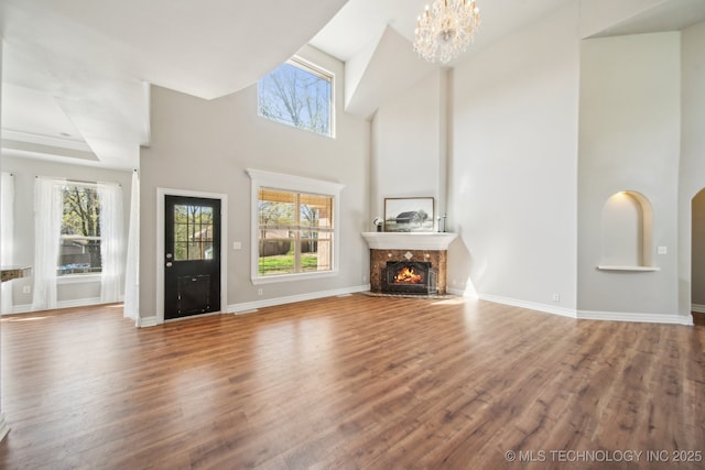 12916 E 181st St S, Bixby, OK 74008 - unfurnished living room with healthy amount of natural light, a fireplace, a towering ceiling, and wood finished floors