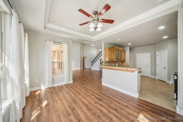 12916 E 181st St S, Bixby, OK 74008 - kitchen with tasteful backsplash, a ceiling fan, glass insert cabinets, brown cabinetry, and light countertops