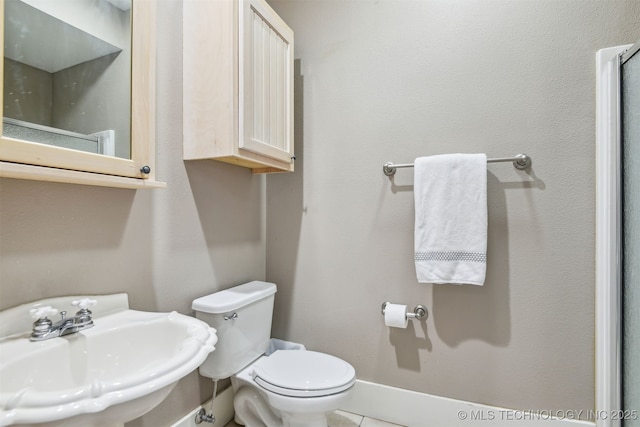 447560 Angler Way, Vinita, OK 74301 - bathroom featuring toilet, a sink, tile patterned floors, and baseboards