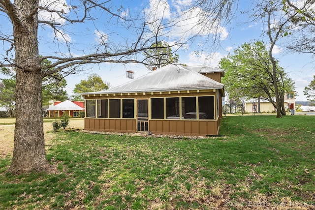 447560 Angler Way, Vinita, OK 74301 - rear view of house featuring board and batten siding, a sunroom, metal roof, and a lawn