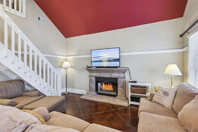 447560 Angler Way, Vinita, OK 74301 - tiled living room featuring visible vents, a high ceiling, a lit fireplace, and stairway