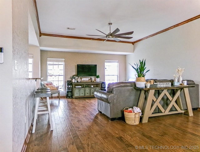 living room with wood-type flooring, visible vents, ornamental molding, and a ceiling fan