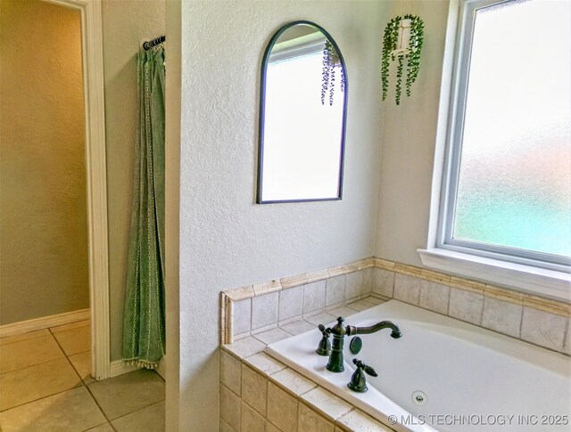 full bathroom with tile patterned flooring, a textured wall, and a garden tub