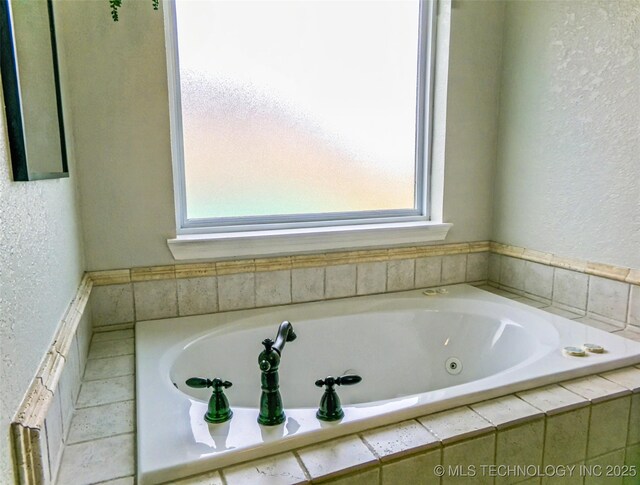 full bathroom with a textured wall and a jetted tub