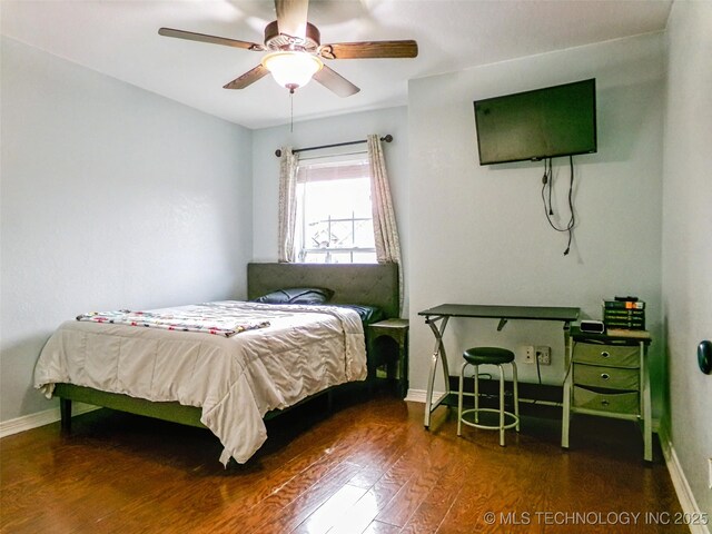 bedroom featuring baseboards, wood finished floors, and a ceiling fan