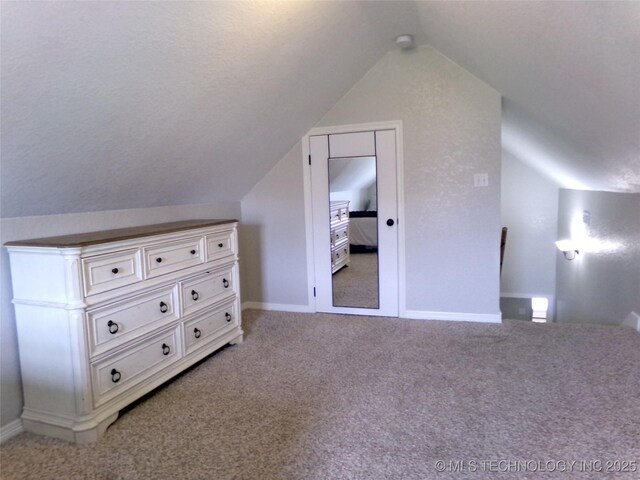 bonus room featuring baseboards, lofted ceiling, and light colored carpet