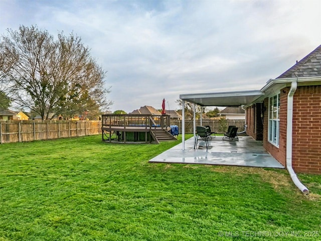 view of yard with a fenced backyard, a deck, and a patio area