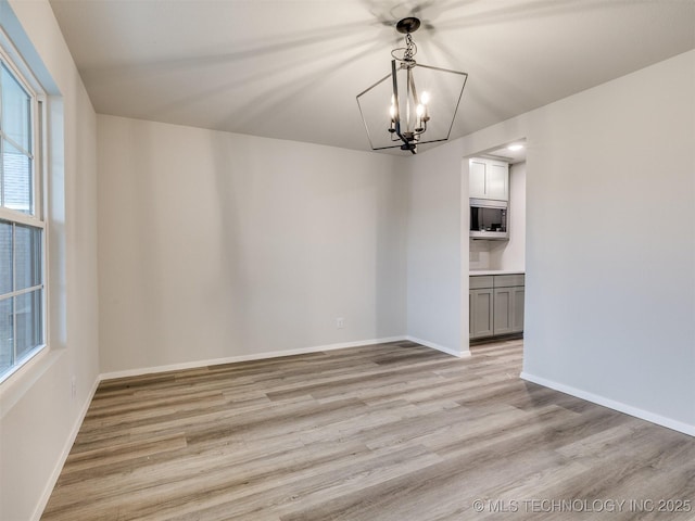 13406 E 124th St, Collinsville, OK 74021 - unfurnished dining area featuring an inviting chandelier, baseboards, and light wood finished floors